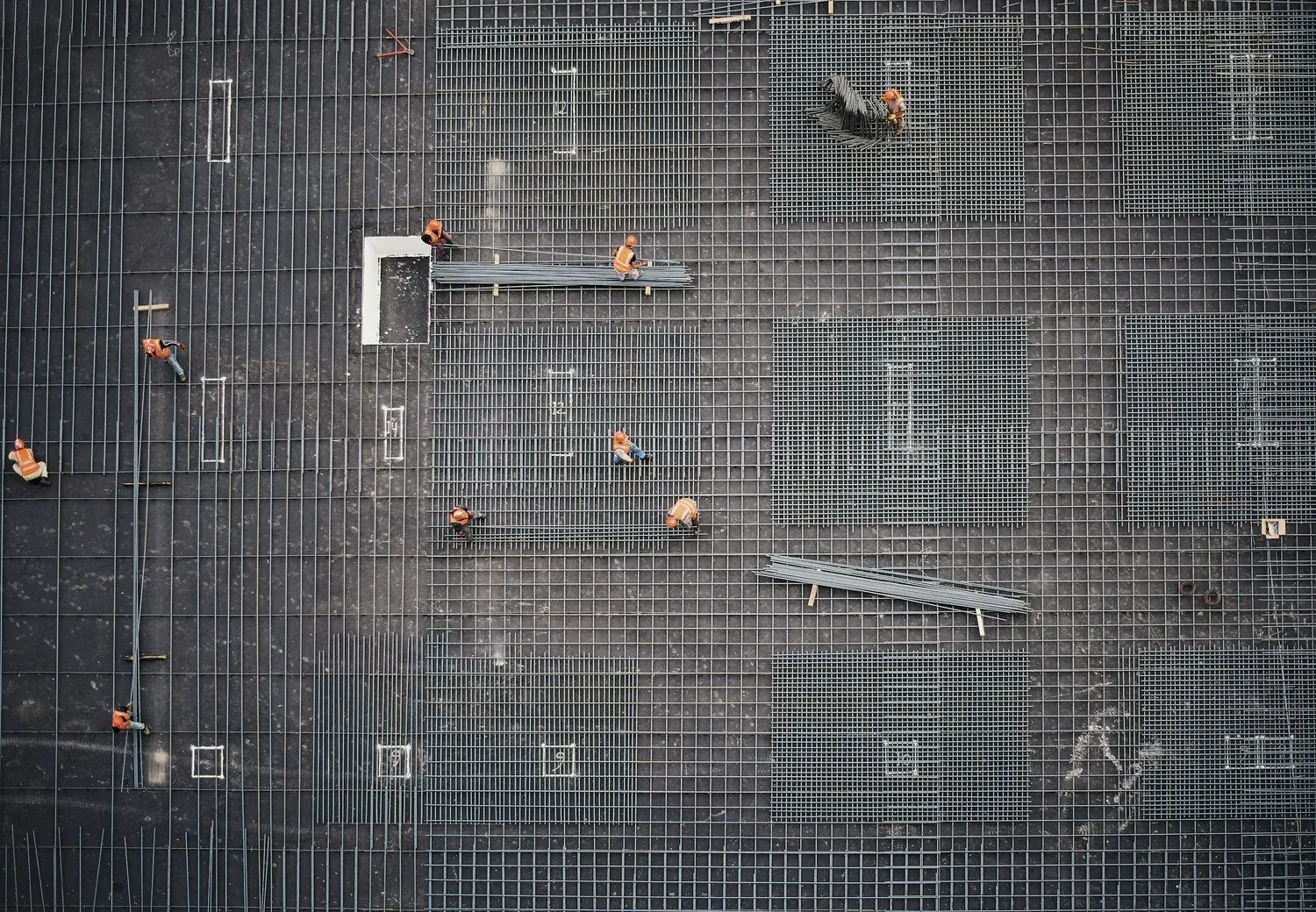 Rebar being laid across a slab on an industrial construction site